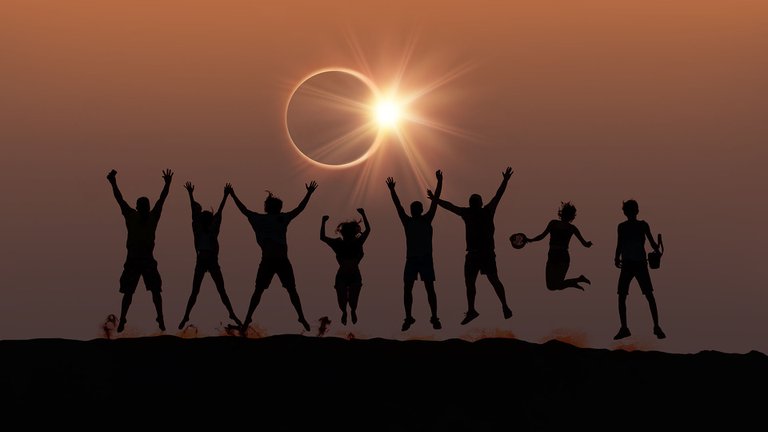 Personas saltando con eclipse total de sol